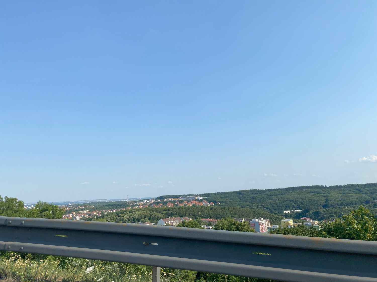 uitzicht vanuit auto met stad en groene heuvels in Tsjechië