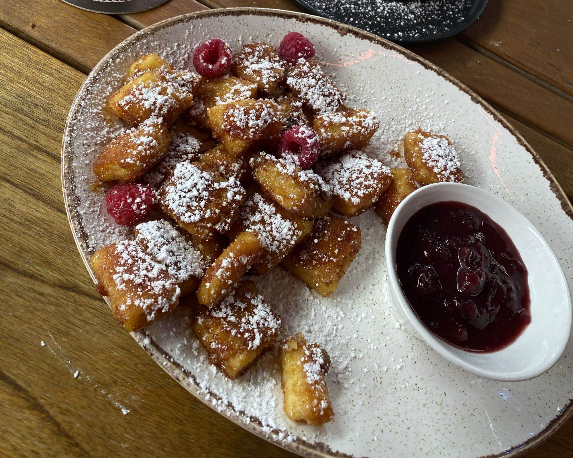 Oostenrijkse Kaiserschmarrn met poedersuiker, frambozen en vruchtencompote