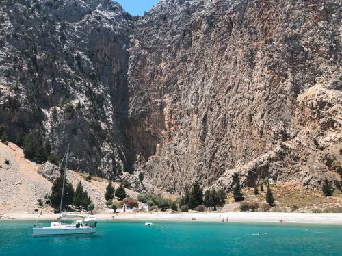 Griekenland – baai met helderblauw water en boot – zonvakantie